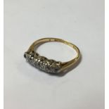 AN 18CT GOLD AND DIAMOND FIVE STONE RING Set with graduated round cut diamonds on a pierced clasp (