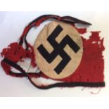 A WORLD WAR II GERMAN SS ARMBAND The oval Nazi insignia set on red fabric with two black bands