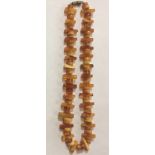 A VINTAGE NATURAL BALTIC AMBER NECKLACE The single strand of rectangular cut sections interspersed