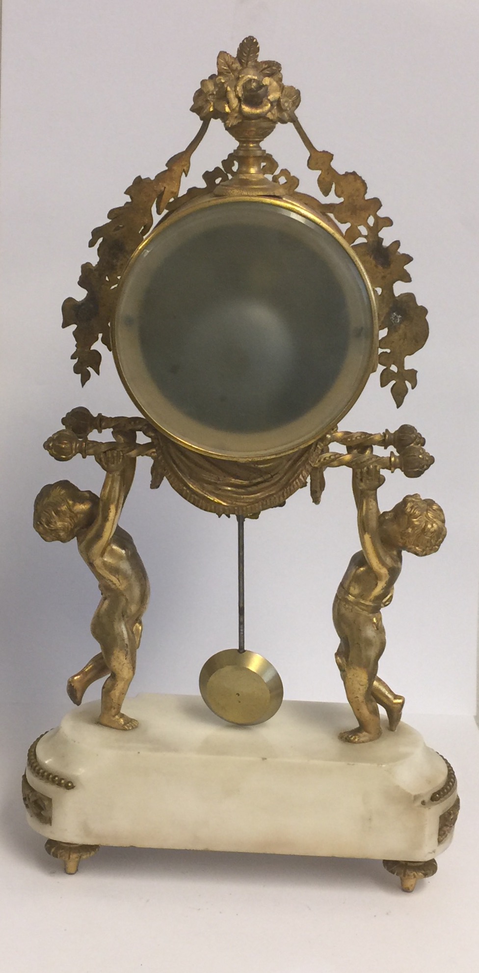 A 19TH CENTURY GILT BRONZE AND WHITE MARBLE DRUM CLOCK Held aloft by two putti. (38cm x 21cm x 9cm) - Image 3 of 5