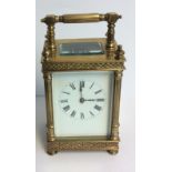 A 19TH CENTURY GILDED BRONZE CARRIAGE CLOCK Having applied scrolled decoration and column