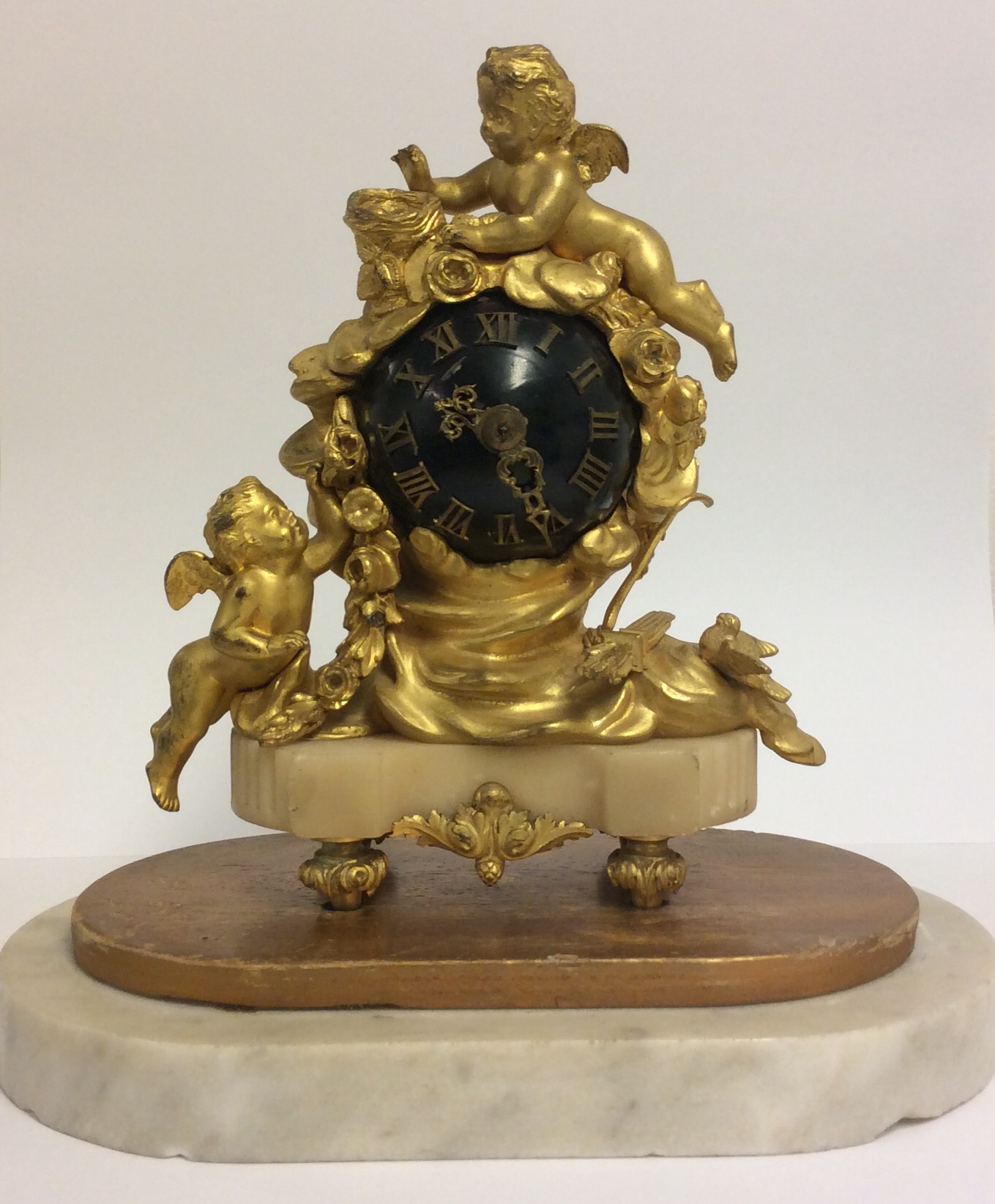A 19TH CENTURY BRONZE ORMOLU AND MARBLE GLOBE DESK CLOCK Mounted with a winged cherub and a birds