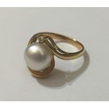 AN 18CT GOLD, DIAMOND AND PEARL RING Having a single diamond and large pearl contained on a curved