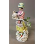 MEISSEN, A FIGURE OF A WOMAN Holding a birdcage, with a sheep at her feet. (h 26cm)