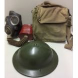 A WORLD WAR II BRITISH HELMET AND GAS MASK The helmet having a recent repaint and the gas mask,