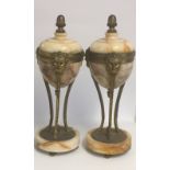 A PAIR OF VEINED MARBLE AND GILT METAL MOUNTED CLOCK GARNITURES Figured with facial masks. (30cm)