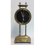AN EARLY 20TH CENTURY BRASS GRAVITY CLOCK The circular dial with visual escapement, the frame marked