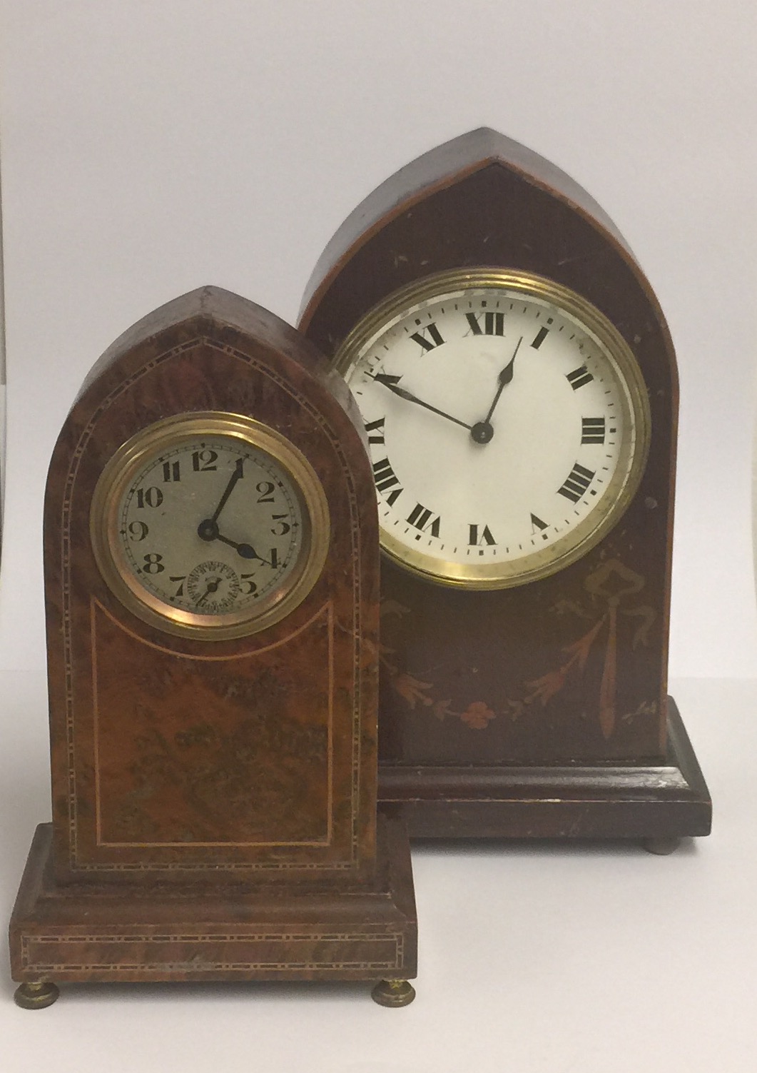 A LATE 19TH CENTURY AMBOYNA CASED CLOCK OF GOTHIC DESIGN Along with a mahogany and inlaid clock of
