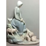 LLADRO, A VINTAGE PORCELAIN FIGURAL GROUP A seated maiden tending to pigs. (approx 28cm)