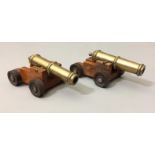 A PAIR OF BRASS DESK TOP CANNONS Having brass barrels, raised on a fruitwood base with four