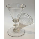 A LATE 18TH CENTURY GLASS CORDIAL GLASS the trumpet form bowl is supported on a diminutive knopped