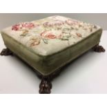 A 19TH CENTURY RECTANGULAR MAHOGANY FOOTSTOOL With floral wool work tapestry, raised on lion paw