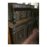 A 17TH CENTURY OAK COURT CUPBOARD With an arrangement of heavily carved doors and drawers. (135cm