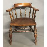 A VICTORIAN OAK AND ELM CAPTAIN'S CHAIR With turned spindle rail and serpentine shaped seat.
