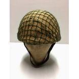 A POST WAR 1973 BRITISH PARATROOPERS HELMET Hessian and net covered.