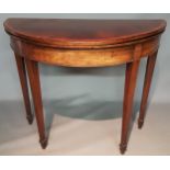 A GEORGE III PERIOD MAHOGANY DEMILUNE FOLD OVER CARD TABLE With green baize playing surface,