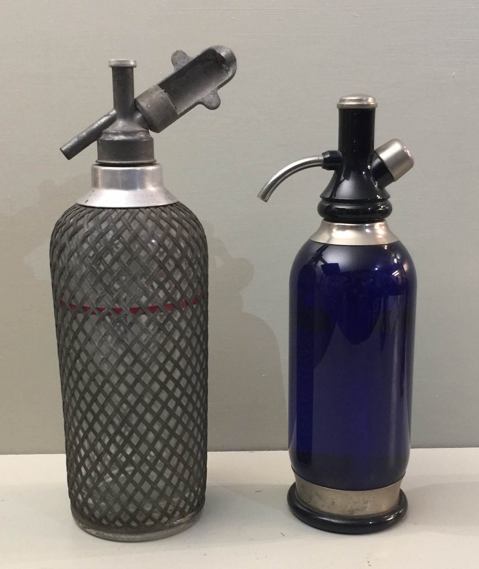 A BRISTOL BLUE SODA SIPHON Along with another.