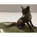 AN EARLY 20TH CENTURY GREEN ONYX OVAL ASHTRAY Figured with a cold painted statue of a fox.