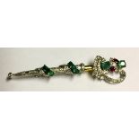 A DIAMOND, EMERALD AND RUBY ENCRUSTED BROOCH FORMED AS A SWORD. (8cm)