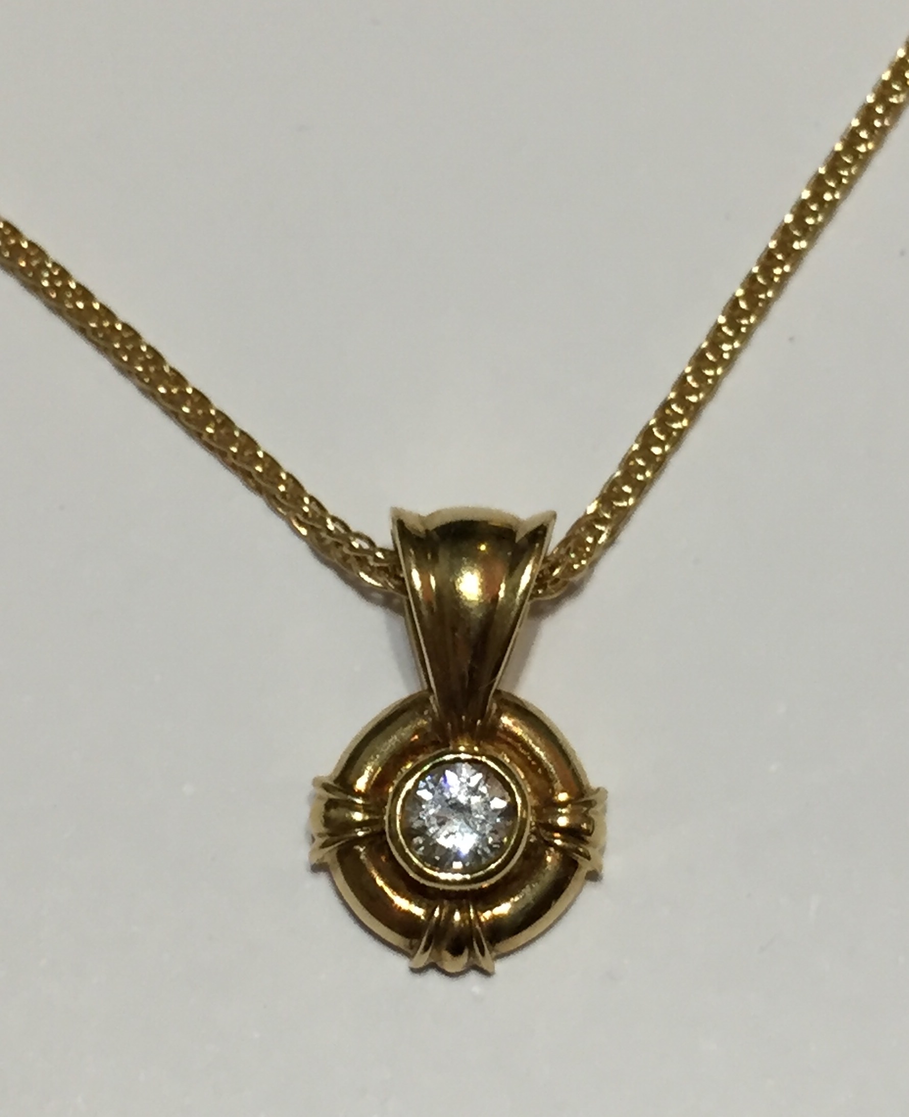 AN 18CT GOLD AND DIAMOND PENDANT The single stone set on a circular clasp, complete with chain. - Image 2 of 2