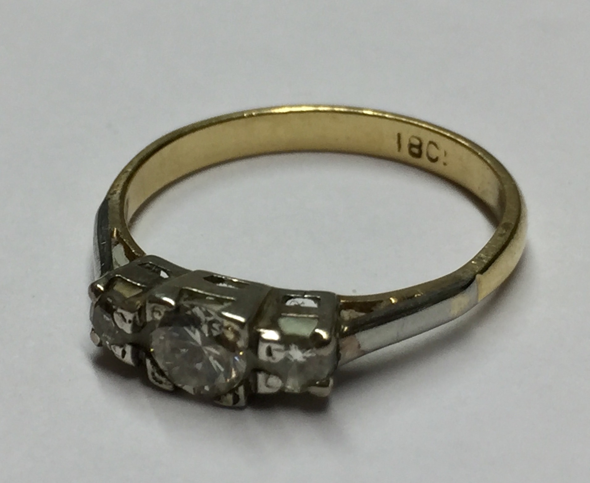 AN 18CT GOLD AND DIAMOND THREE STONE RING With central round cut diamond flanked by two smaller (