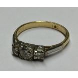 AN 18CT GOLD AND DIAMOND THREE STONE RING With central round cut diamond flanked by two smaller (
