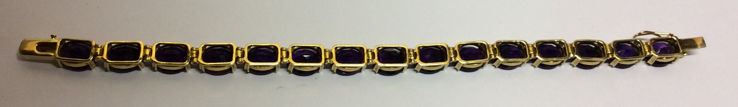 AN 18CT GOLD AND AMETHYST BRACELET Having a single row of oval cut amethysts set in articulated - Image 3 of 3