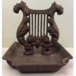 A VICTORIAN CAST IRON BOOT SCRAPER Having a Classical style lyre, held in a rectangular tray with