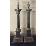 A PAIR OF SILVER PLATED TABLE LAMPS In the form of columns with Corinthian capitals. (40cm)