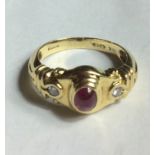 AN 18CT GOLD, RUBY AND DIAMOND ETRUSCAN STYLE RING Having a cabochon cut ruby flanked by two round