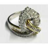 AN 18CT WHITE AND YELLOW GOLD DIAMOND RING The ribbon set with baguette and brilliant cut