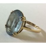 A VINTAGE 9CT GOLD AND PASTE SET DRESS RING Having an oval facet cut stone claw set in a plain