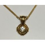 AN 18CT GOLD AND DIAMOND PENDANT The single stone set on a circular clasp, complete with chain.