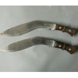 A PAIR OF EARLY 20TH CENTURY KUKRIS With hardwood grips.