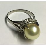 A PLATINUM, PEARL AND DIAMOND DRESS RING (size O).