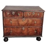 AN EARLY 18TH CENTURY WALNUT CHEST Of two short above two long drawers, with brass tier drop handles