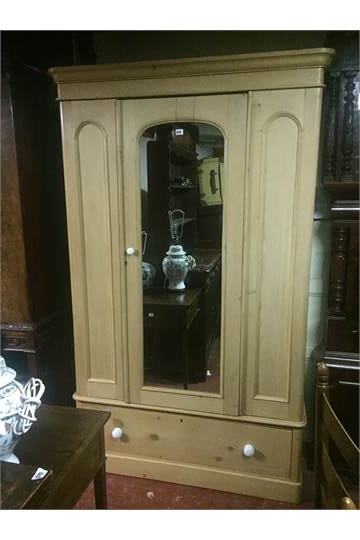 A VICTORIAN PINE WARDROBE With a single mirrored door above a drawer. (124cm x 195cm x 63cm)