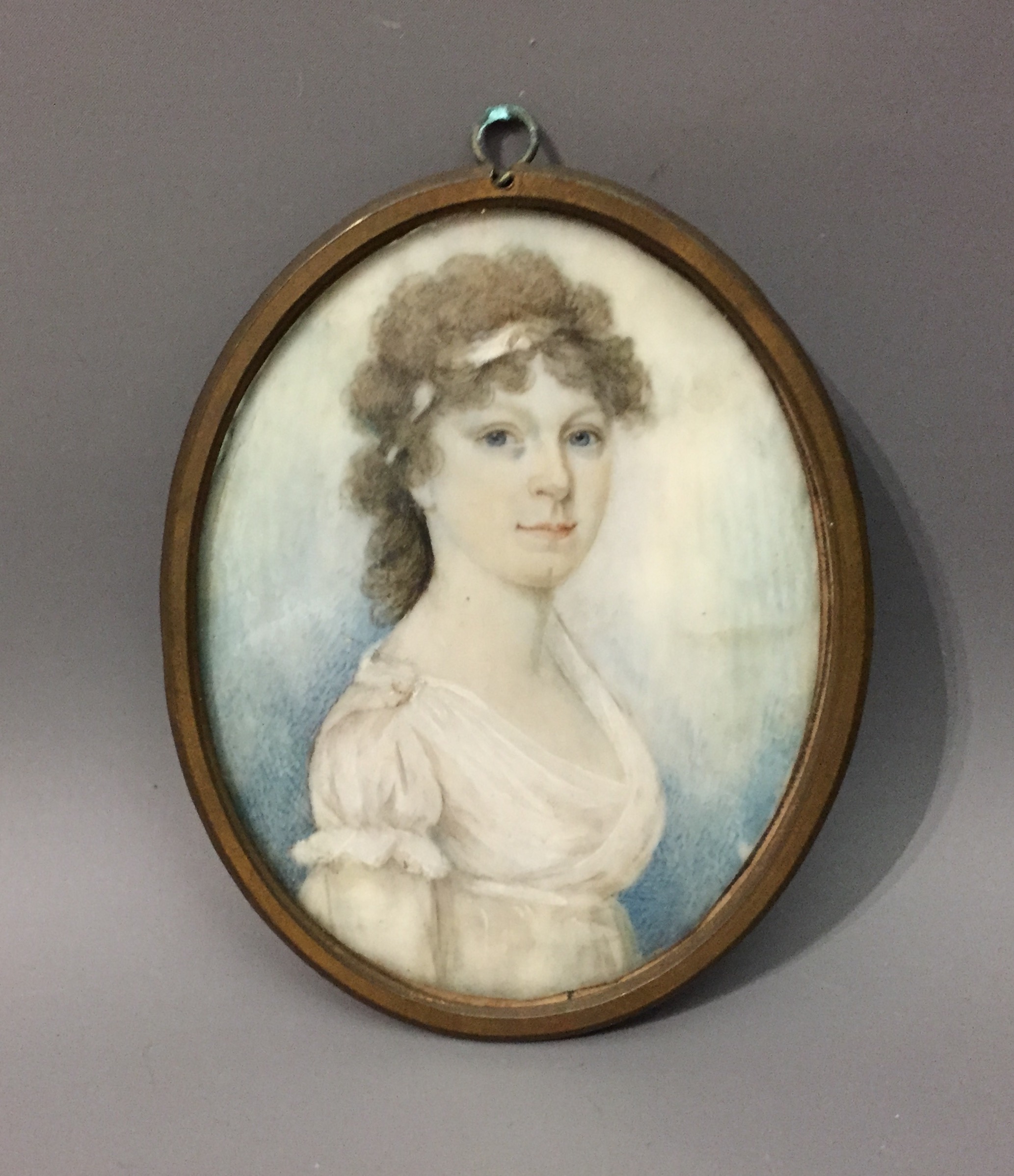 CIRCLE OF THOMAS HAZELHURST, A 19TH CENTURY PORTRAIT MINIATURE Depicting a Regency lady in a white