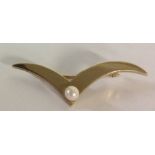 A VINTAGE 9CT GOLD AND PEARL BROOCH Cast as stylized wings and set with a single pear. (approx 4.