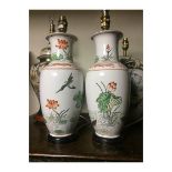 A PAIR OF CHINESE FAMILLE VERTE SHOULDERED OVOID PORCELAIN VASES (now wired for use as table