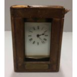 AN EDWARDIAN BRASS CARRIAGE CLOCK In a leather carrying case.