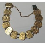 A 9CT GOLD BRACELET Having twelve engraved panels, all with foliate scroll motifs.