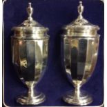 A CASED PAIR OF VINTAGE NEOCLASSICAL STYLE SILVER SUGAR CASTERS Having an urn shape finial and