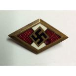 A GOLD ENAMELLED HITLER YOUTH BADGE No: 115278. Condition: good enamel