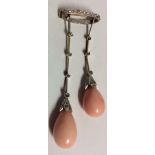 AN EDWARDIAN ANGELSKIN CORAL AND DIAMOND BROOCH Comprising a pair of coral drops and