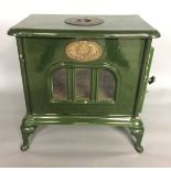 A CIRCA 1980 'MORLEY' WOODBURNING STOVE The green enamelled exterior with oval brass plaques