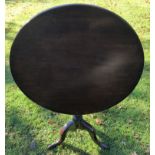 AN 18TH CENTURY MAHOGANY TILT TOP OCCASIONAL TABLE The circular top raised on a turned column,