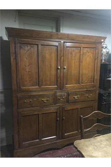 A 19TH CENTURY PINE HOUSE KEEPERS CABINET With four doors and three central drawers, raised on a