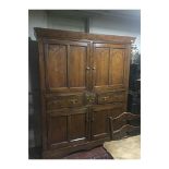 A 19TH CENTURY PINE HOUSE KEEPERS CABINET With four doors and three central drawers, raised on a
