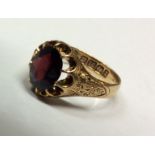 A VINTAGE 18CT GOLD AND GARNET GENT'S SIGNET RING Having a single oval cut garnet claw set and the